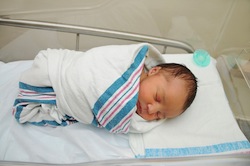 newborn baby wrapped in blanket in hospital small